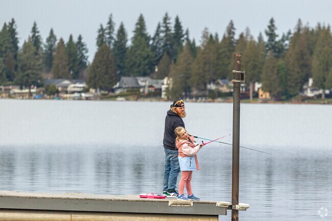 A father and daughter cast a line in the Alderton area on a partly cloudy day.