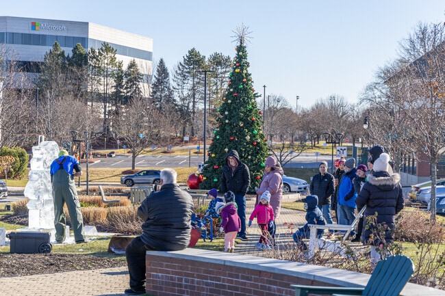 Families gather around to watch the Ice Carving demo at Winter Wonderland near Woods Corner.