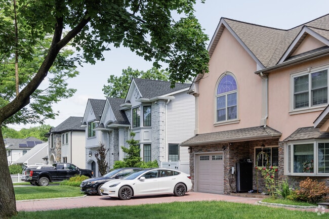 Electric cars are parked in front of newly constructed houses in Paramus, NJ.
