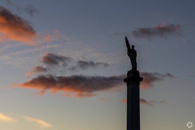A memorial statue overlooks Lock Haven as the sun sets.