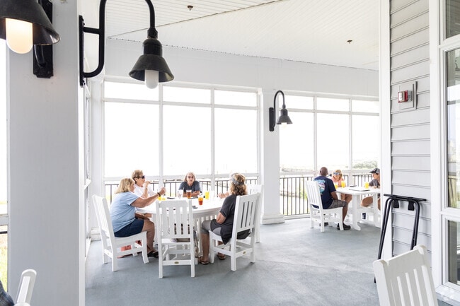 Dining al fresco at Marina Club patio in Captain's Cove offers scenic water views in Greenbackville.
