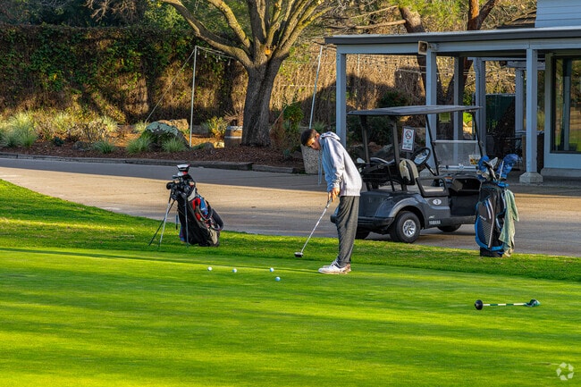 Boy practices putt at Diamond Oaks Golf Course in Diamond Oaks neighborhood.
