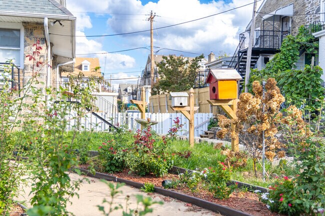 A lovely front walkway with colorful flowers and birdhouses.
