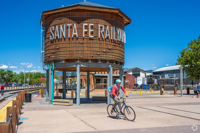 A cyclist rides past the shops, galleries and the picturesque Railyard Water Tower.