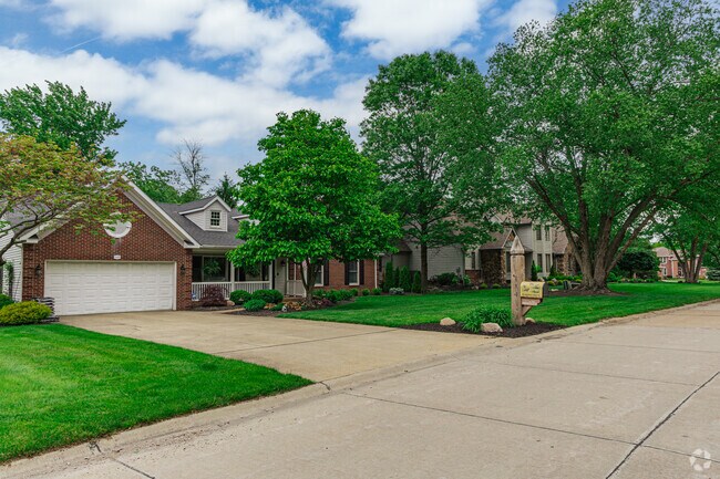 A row of modest brick ranch and colonial houses lines a quiet street near Quail Hollow Country Club.