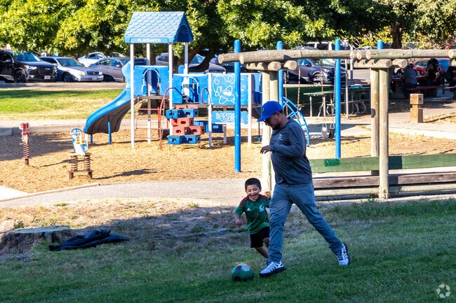 Dad is playing soccer with his son at Hawyward's San Felipe Park.