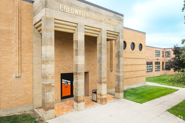 Coldwater High School entrance with stone portico, fluted columns, and Cavaliers branding.