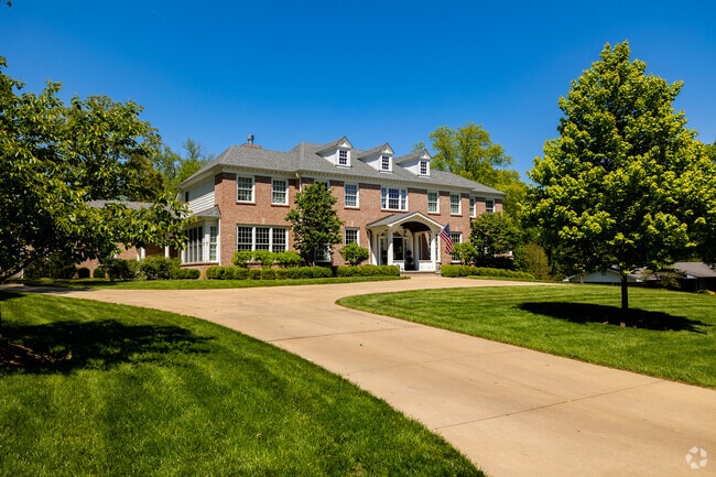 A large 2 story home in the Frontenac neighborhood invites guests with a wide circle drive.