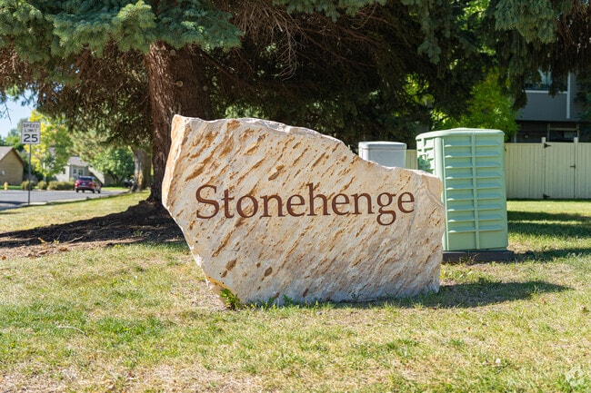 A large stone sign welcomes visitors to the quiet Stonehenge neighborhood.