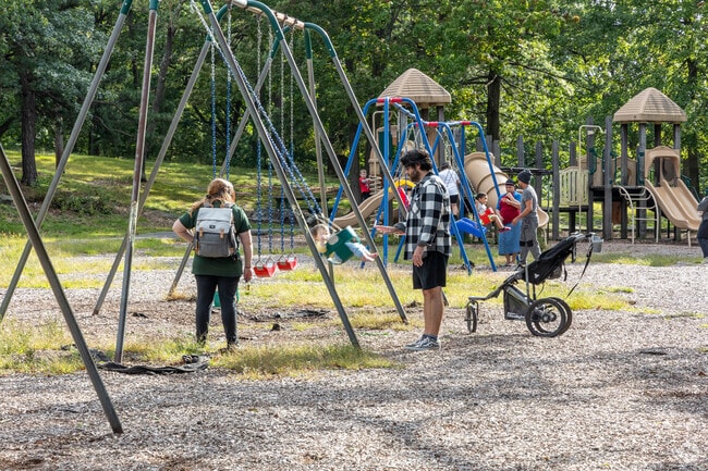 Kids play on the swings at Nay Aug Park, minutes from the Greenridge neighborhood.