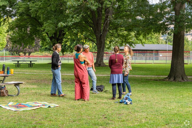 A group of South Ashland mothers enjoy harmonizing their homeland song while their kids play.