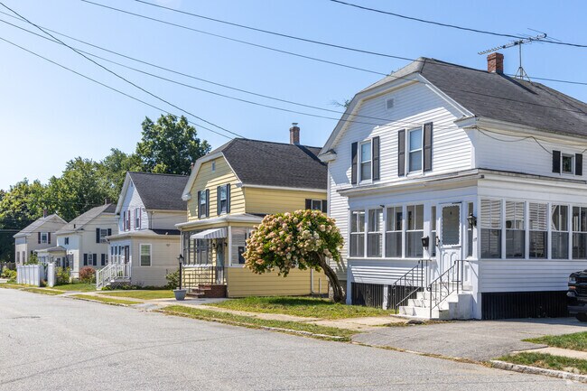A row of New Englander styled homes with front porches that are commonly found in The Highlands.