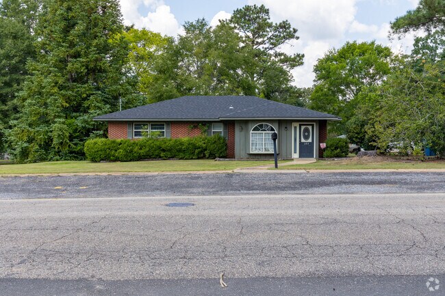 A classic brick exterior and arched window highlight this single-story home on a quiet residential street.
