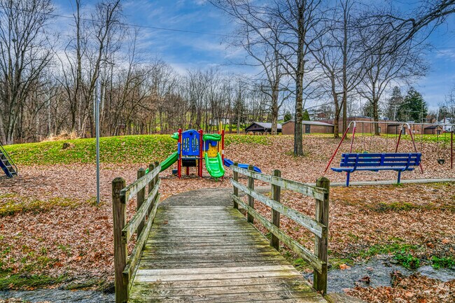 A bridge spans the creek in Bentleyville Richardson Park in order to reach a small playground.