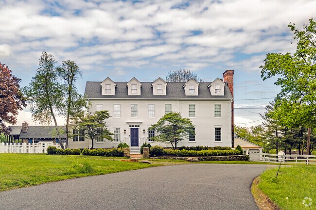 Stately and serene, this grand colonial home blends classic elegance with pastoral views on a quiet, winding road.