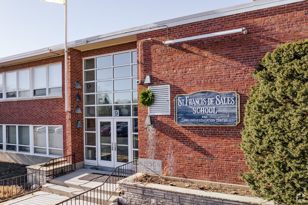 The front entrance to St Francis de Sales School features a brick and glass facade.