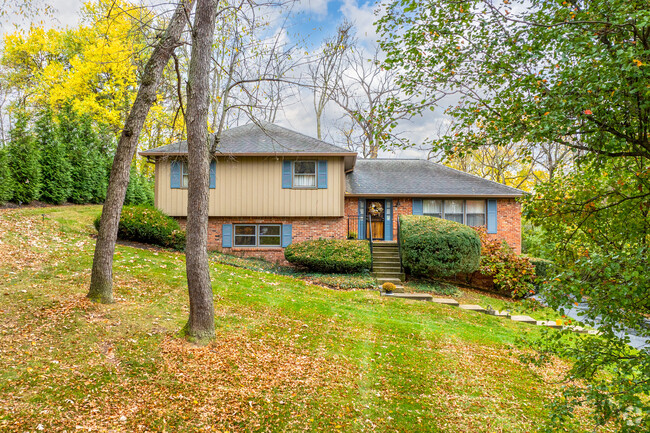 Split level homes sit on sloped Devon lots with tall shading trees.