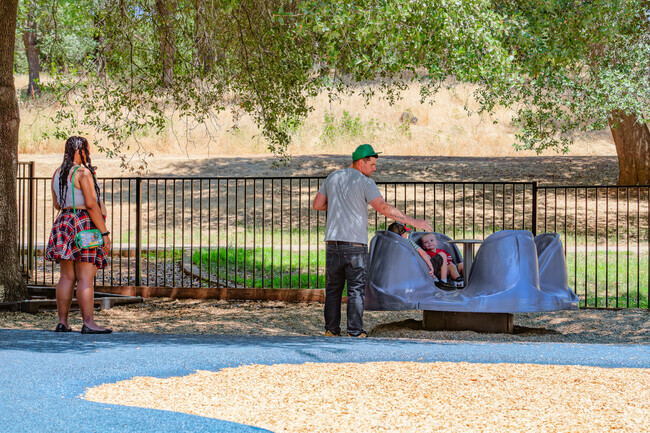 Dad spins kids on the marry go round at Kids Kingdom in Alta Mesa.