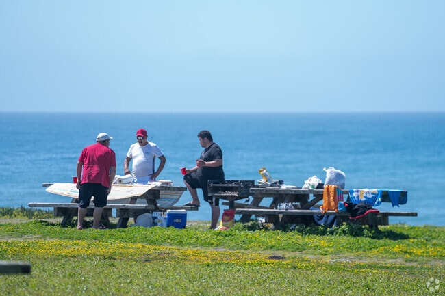 Surf aficionados in Half Moon Bay gear up for the waves, embodying the surf spirit.