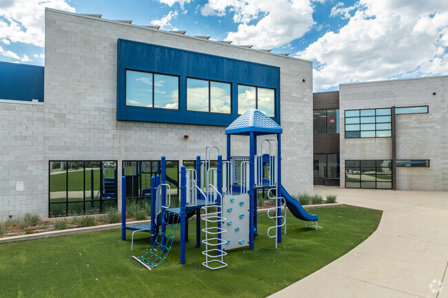 A blue and gray playground matches the building at Early Light Academy.