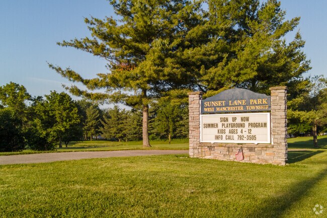 Park sign with summer programs listed at Sunset Lane Park.