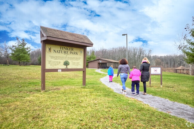 A group of people walking in Tinker Nature Park.