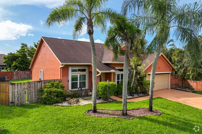 Traditional single family home with palm trees in Royal Palm Beach neighborhood.