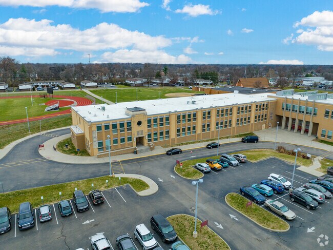 There is a track stadium behind the school building.
