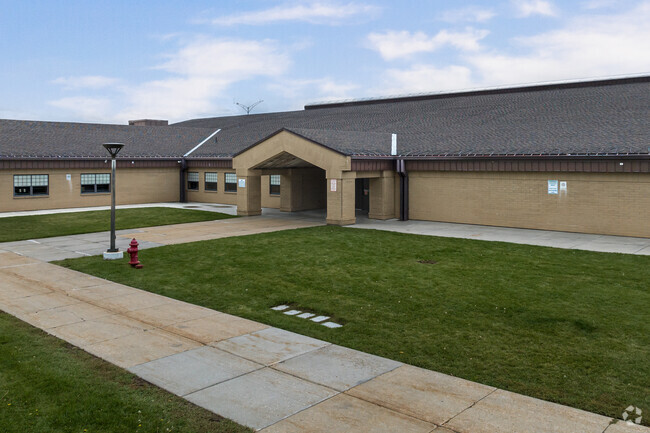 The entrance at Snowcrest Junior High School has green lawns and wide sidewalks.