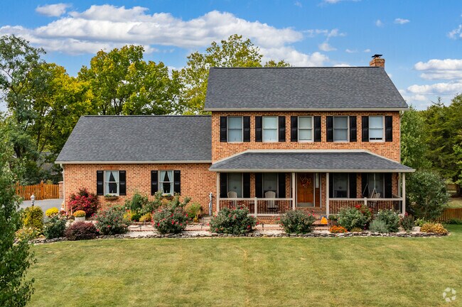 A gorgeous colonial style home with a large front porch and details landscaping in Downsville.