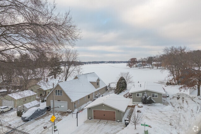 Lakefront homes in Zimmerman, Minnesota, overlooking a frozen shoreline and snow-covered landscape near Fremont Lake.