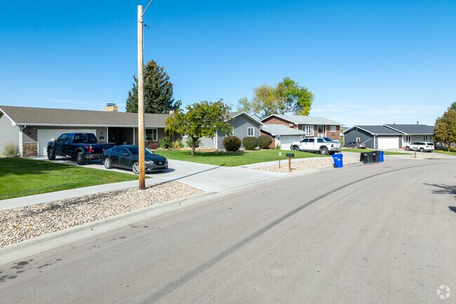 Ranch‑style homes show tidy yards and driveways along the block.