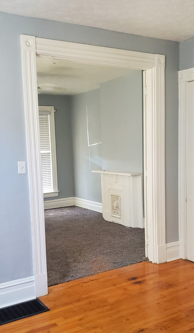 Front room carpet with ceiling fan, adjacent room hardwood floor for office or studeo