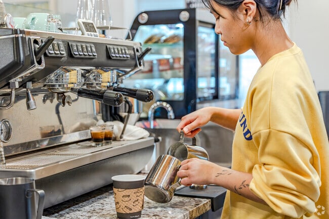 Friendly barista whips up a latte at Cafe Community Bean in Oakbrook area.