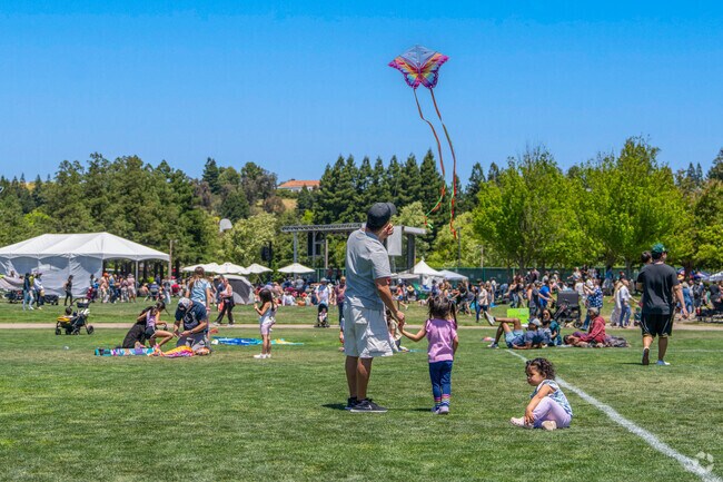 The field at Central Park is filled with parents and children flying kites during Art and Wind.