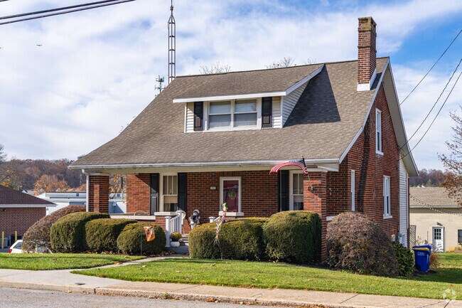 A cozy brick Bungalow with a wide shaded front porch in New Freedom.