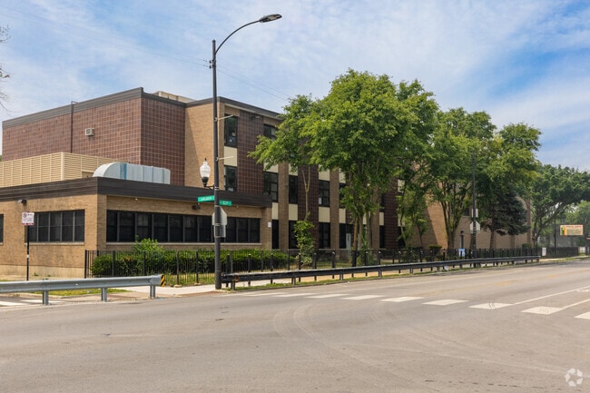 Marcus Garvey Elementary School campus building lined by trees, Chicago, IL.