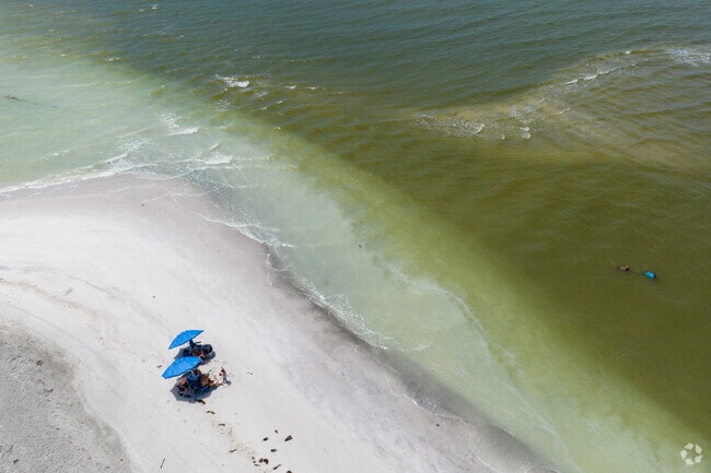 People under umbrellas on Blind Pass Beach in West End, Sanibel.