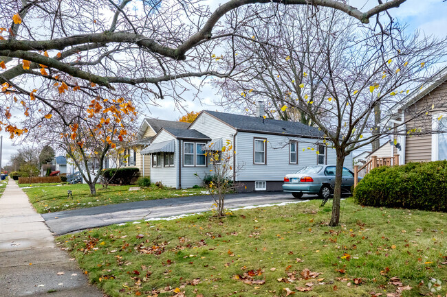 Homes in West Waukegan sit behind grassy front yards with sidewalks under mature trees.