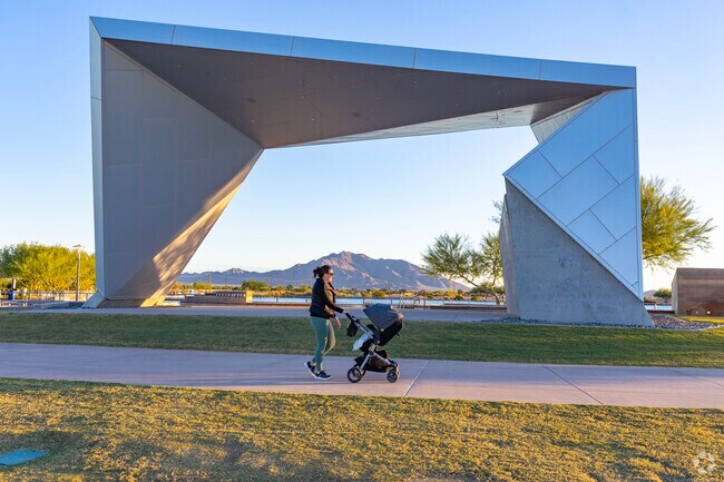 A mother walks past a huge geometric sculpture at The Bridges at Gilbert.