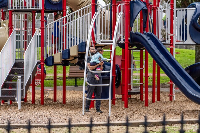 A father and child play at one of Nassau Bay's expansive playground sets.