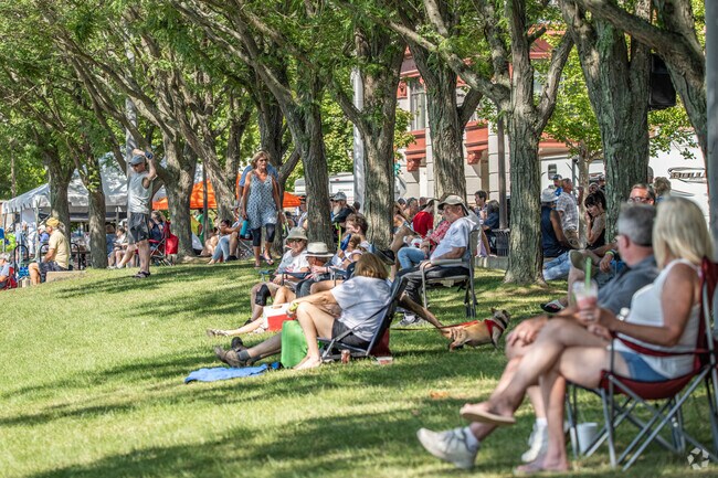 People where sitting in the shade on a hot day to watch the Wheeling Regatta.
