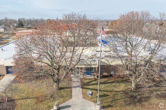CH Bird Elementary School has mature trees in front of the building.