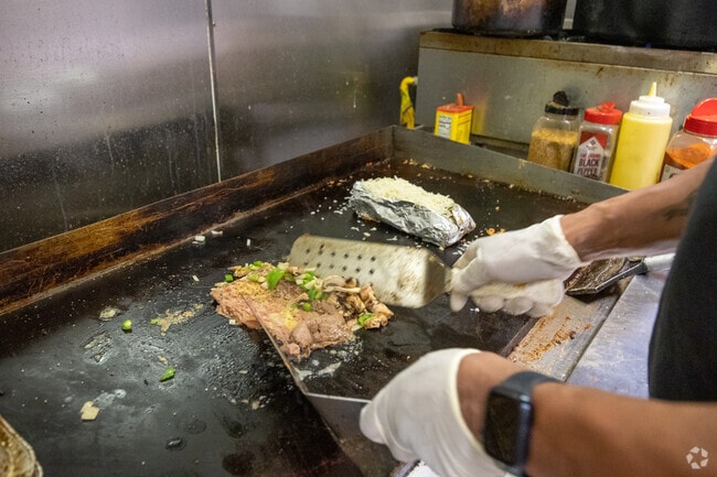 The Sleepy Potato co-owner, Marlon, prepares a signature potato dish in Oakman Boulevard Community.