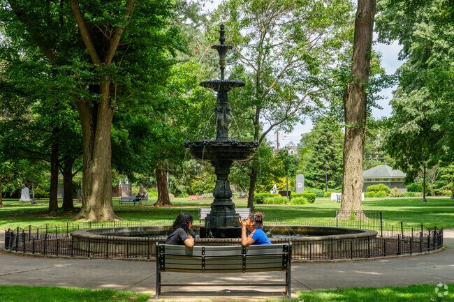 Friends chat beside the water fountain in West Park in Allentown.