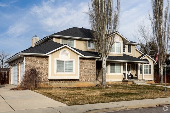 A traditional two-story suburban home, with Craftsman-influenced details, in Orchard South, combine stone and stucco for a warm, welcoming look.