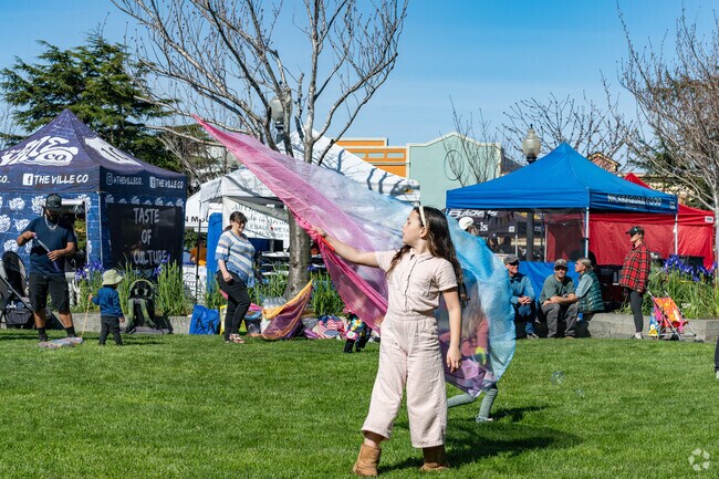 Children enjoy dancing around on the lawn at the Arcata Plaza Farmers' Market.