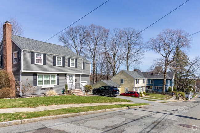 A row of homes including several Garrison styled homes line the street in Wakefield, MA.