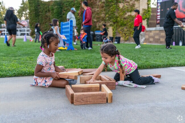 Little girls play with blocks while waiting for the movie to start at Family Movie Nights.