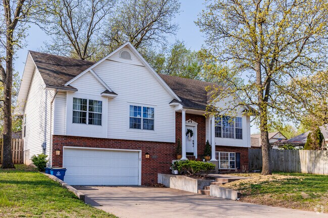A split level home is surrounded by large trees in Kelsey Norman South.
